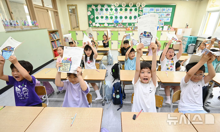[수원=뉴시스] 김종택 기자 = 여름방학식이 열린 27일 경기 수원시 장안구 효천초등학교에서 1학년1반 학생들이 방학안내문을 들어보이고 있다. 2026.07.27. jtk@newsis.com