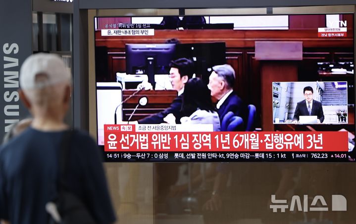 [서울=뉴시스] 김명년 기자 = 대선후보 시절 건진법사 전성배 씨에 관한 허위사실을 공표한 혐의로 기소된 윤석열 전 대통령 1심 선고 공판이 열린 27일 서울역에서 시민들이 관련 방송을 지켜보고 있다. 이날 재판부는 윤 전 대통령에게 징역 1년 6개월에 집행유예 3년을 선고했다. 2026.07.27. kmn@newsis.com