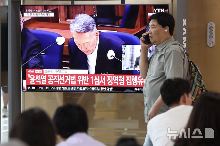 [서울=뉴시스] 김명년 기자 = 대선후보 시절 건진법사 전성배 씨에 관한 허위사실을 공표한 혐의로 기소된 윤석열 전 대통령 1심 선고 공판이 열린 27일 서울역에서 시민들이 관련 방송을 지켜보고 있다. 이날 재판부는 윤 전 대통령에게 징역 1년 6개월에 집행유예 3년을 선고했다. 2026.07.27. kmn@newsis.com
