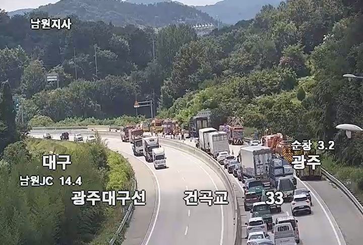 [순창=뉴시스] 28일 오후 1시56분께 전북 순창군 유등면을 지나는 광주대구고속도로 광주 방면 32㎞ 지점에서 주행 중이던 대형 화물차에 불이 나 소방대원들이 현장에서 진화 작업을 벌이고 있다. (사진=도시교통정보센터 폐쇄회로카메라 화면 갈무리) 2026.07.28. photo@newsis.com *재판매 및 DB 금지