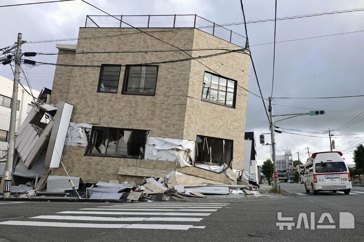 [야쓰시로=AP/뉴시스] 일본 국토지리원은 28일 발생한 구마모토(熊本)현의 규모 7.1 강진으로 최대 84㎝ 지각변동이 관측됐다고 발표했다. 사진은 일본 규슈 서부 구마모토현 야쓰시로에서 29일 구급차 한 대가 전날 발생한 지진으로 주저앉은 건물 옆을 지나고 있는 모습. 2026.07.29.