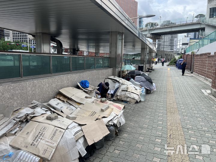 [서울=뉴시스]김범준 인턴기자=지난 27일 오전 찾은 서울역 광장 인근. 노숙인들이 더위를 피하기 위해 박스 여러 개를 펼쳐 임시 그늘막을 만든 모습. 2026.07.30 photo@newsis.com