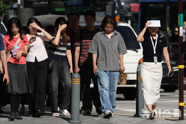 [서울=뉴시스] 김명년 기자 = 사진은 지난달 29일 서울 중구 세종대로 사거리에서 시민들이 손으로 햇볕을 가리며 이동하고 있는 모습. 2026.07.29. kmn@newsis.com