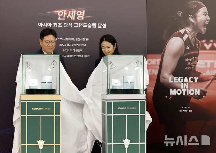 [서울=뉴시스] 김혜진 기자 = 성창훈(왼쪽) 한국조폐공사 사장과 안세영이 29일 서울 서초구 요넥스 코리아에서 열린 안세영 공식 기념메달 공개식에서 기념메달을 공개하고 있다. 2026.07.29. jini@newsis.com