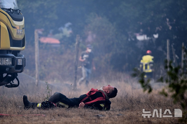 [블라공=AP/뉴시스] 29일(현지 시간) 프랑스 남서부 블라공 인근 숲에서 산불 진화 작업 소방관이 땅바닥에 등을 대고 누워 잠시 쉬고 있다. 2026.07.30.