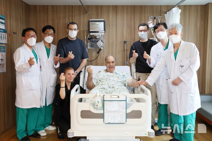 [서울=뉴시스] 모로코 삼부자 가족이 2대1 생체간이식 수술을 집도한 서울아산병원 간이식·간담도외과 의료진과 기념촬영을 하고 있다. 왼쪽 첫 번째부터 문덕복·송기원 교수, 기증자인 첫째 아들 하침씨, 수혜자의 아내, 수혜자 모하메드씨, 기증자인 둘째 아들 오마르씨, 정동환 교수·이승규 석좌교수. (사진= 서울아산병원 제공)