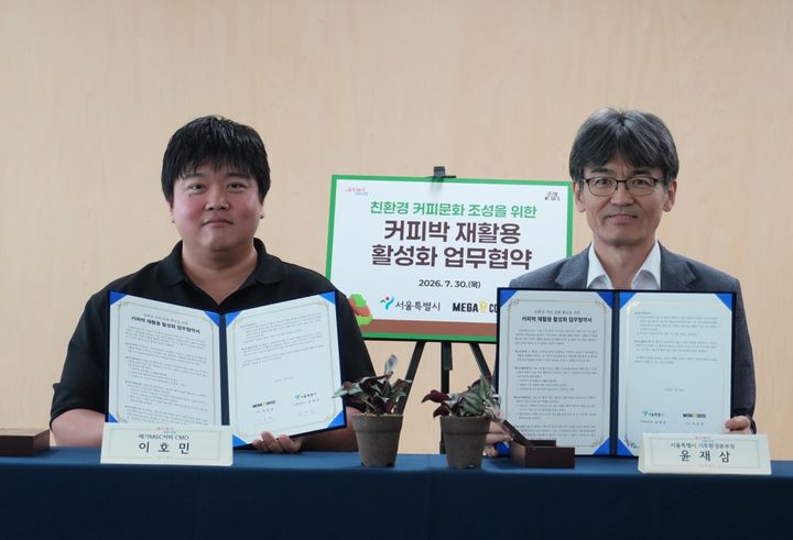 [서울=뉴시스] 이호민(왼쪽) 메가MGC커피 최고마케팅책임자(CMO)와 윤재삼 서울시 기후환경본부장이 지난 30일 서울시청에서 커피박 재활용 활성화 업무협약을 체결한 뒤 기념촬영을 하고 있다. (사진=서울시 제공) 2026.07.31. photo@newsis.com *재판매 및 DB 금지