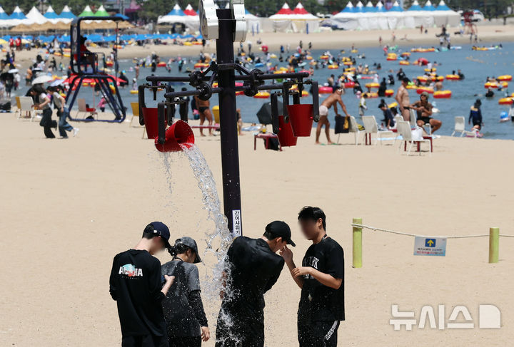  [부산=뉴시스] 하경민 기자 = 부산 서부·중부에 폭염중대경보가 발효된 30일 부산 수영구 광안리해수욕장에서 피서객들이 물벼락을 맞으며 더위를 식히고 있다. 2026.07.30. yulnetphoto@newsis.com
