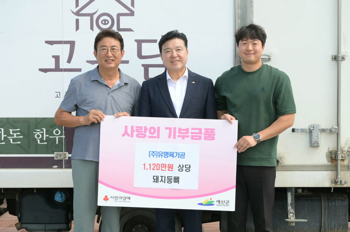 [예산=뉴시스] 고성만(왼쪽) 유명육가공 대표와 고종연(오른쪽) 팀장이 지난 30일 예산군청을 들러 최재구 군수에게 지역 어르신 건강 여름나기를 위한 돼지등뼈 3200㎏을 기탁하며 기념 사진을 찍고 있다. (사진=예산군 제공) 2026.07.31. photo@newsis.com *재판매 및 DB 금지