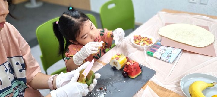 [평창=뉴시스] '과일 푸드아트테라피 프로그램에 참여한 어린이들이 과일을 활용해 작품을 만들고 있다. (사진=평창군 제공) 2026.07.31. photo@newsis.com *재판매 및 DB 금지