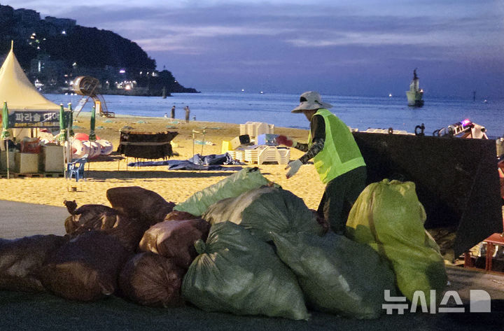 [부산=뉴시스] 김민지 기자 = 31일 오전 부산 해운대구 해운대해수욕장에서 수거한 쓰레기 포대를 정리하고 있는 미화원. 2026.08.01. photo@newsis.com