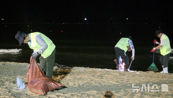 [부산=뉴시스] 김민지 기자 = 31일 오전 부산 해운대구 해운대해수욕장의 백사장에서 쓰레기를 수거하고 있는 미화원들. 2026.08.01. photo@newsis.com
