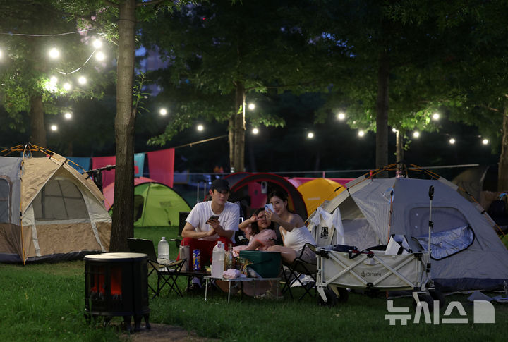 [서울=뉴시스] 이영환 기자 = 1일 오후 서울 영등포구 여의도한강공원 물빛무대 앞 잔디밭에서 운영되는 임시 야영장 한강 밤핑(Night+Camping)을 찾은 시민들이 즐거운 시간을 보내고 있다. 서울시는 휴가철을 맞아 8월 한 달간 여의도·뚝섬 한강공원에서 임시 야영장인 '한강 밤핑(Night+Camping)'을 운영한다. 여의도 한강공원 물빛무대 앞 잔디밭과 뚝섬 한강공원 한강플플 잔디밭에 각각 텐트 100동씩 총 200동 규모 야영장을 조성한다. 운영 시간은 매일 오후 5시부터 다음날 오전 9시까지다. 2026.08.01. 20hwan@newsis.com