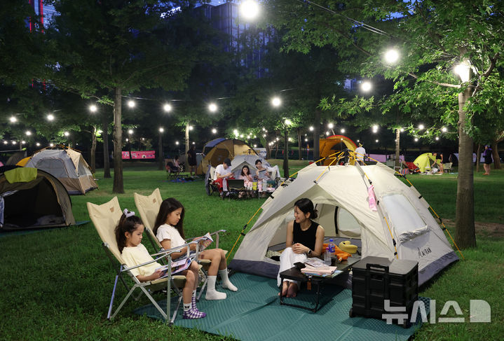 [서울=뉴시스] 이영환 기자 = 1일 오후 서울 영등포구 여의도한강공원 물빛무대 앞 잔디밭에서 운영되는 임시 야영장 한강 밤핑(Night+Camping)을 찾은 시민들이 즐거운 시간을 보내고 있다. 서울시는 휴가철을 맞아 8월 한 달간 여의도·뚝섬 한강공원에서 임시 야영장인 '한강 밤핑(Night+Camping)'을 운영한다. 여의도 한강공원 물빛무대 앞 잔디밭과 뚝섬 한강공원 한강플플 잔디밭에 각각 텐트 100동씩 총 200동 규모 야영장을 조성한다. 운영 시간은 매일 오후 5시부터 다음날 오전 9시까지다. 2026.08.01. 20hwan@newsis.com