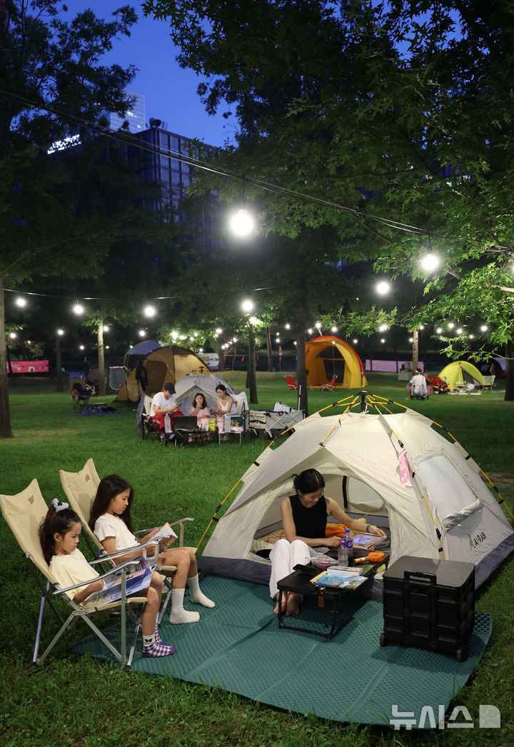 [서울=뉴시스] 이영환 기자 = 1일 오후 서울 영등포구 여의도한강공원 물빛무대 앞 잔디밭에서 운영되는 임시 야영장 한강 밤핑(Night+Camping)을 찾은 시민들이 즐거운 시간을 보내고 있다. 서울시는 휴가철을 맞아 8월 한 달간 여의도·뚝섬 한강공원에서 임시 야영장인 '한강 밤핑(Night+Camping)'을 운영한다. 여의도 한강공원 물빛무대 앞 잔디밭과 뚝섬 한강공원 한강플플 잔디밭에 각각 텐트 100동씩 총 200동 규모 야영장을 조성한다. 운영 시간은 매일 오후 5시부터 다음날 오전 9시까지다. 2026.08.01. 20hwan@newsis.com