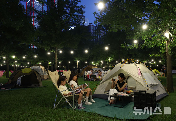 [서울=뉴시스] 이영환 기자 = 1일 오후 서울 영등포구 여의도한강공원 물빛무대 앞 잔디밭에서 운영되는 임시 야영장 한강 밤핑(Night+Camping)을 찾은 시민들이 즐거운 시간을 보내고 있다. 서울시는 휴가철을 맞아 8월 한 달간 여의도·뚝섬 한강공원에서 임시 야영장인 '한강 밤핑(Night+Camping)'을 운영한다. 여의도 한강공원 물빛무대 앞 잔디밭과 뚝섬 한강공원 한강플플 잔디밭에 각각 텐트 100동씩 총 200동 규모 야영장을 조성한다. 운영 시간은 매일 오후 5시부터 다음날 오전 9시까지다. 2026.08.01. 20hwan@newsis.com