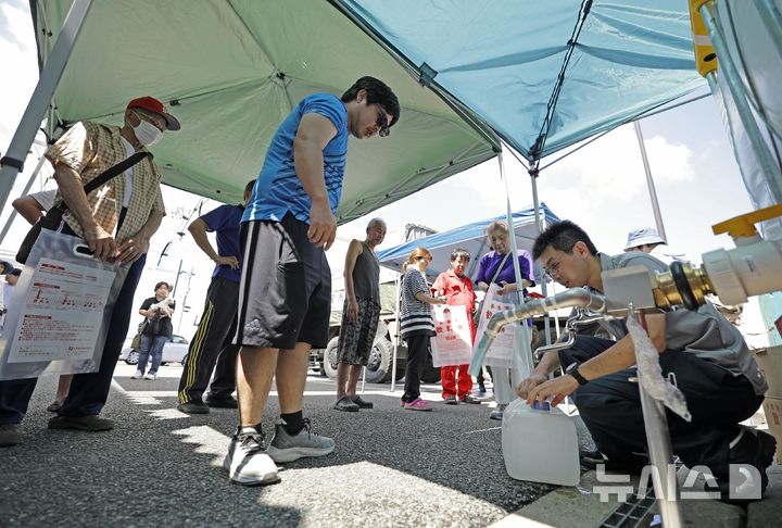 [히카와=AP/뉴시스] 31일(현지시간) 일본 구마모토현 히카와정 주민들이 지진으로 수도 공급이 중단되자 히카와정청에서 급수를 받고 있다. 2026.07.31.