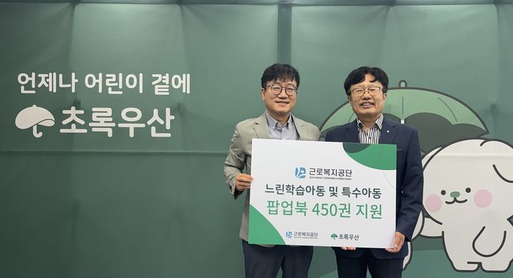 [울산=뉴시스] 박종길 근로복지공단 이사장이 김동환 초록우산 울산지역본부장에게 팝업북을 전달하고 있다. (사진=초록우산 제공) 2026.08.02. photo@newsis.com *재판매 및 DB 금지