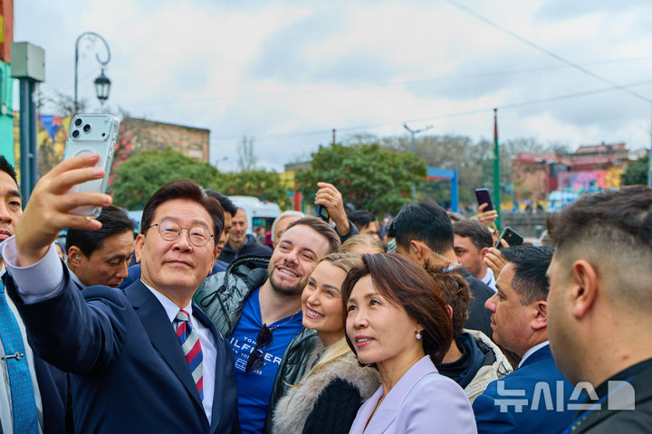 [부에노스아이레스=뉴시스] 김진아 기자 = 이재명 대통령과 김혜경 여사가 1일(현지 시간) 아르헨티나 부에노스아이레스 보카 지구를 방문해 현지 시민들과 인증샷을 찍고 있다. (공동취재) 2026.08.02. bluesoda@newsis.com