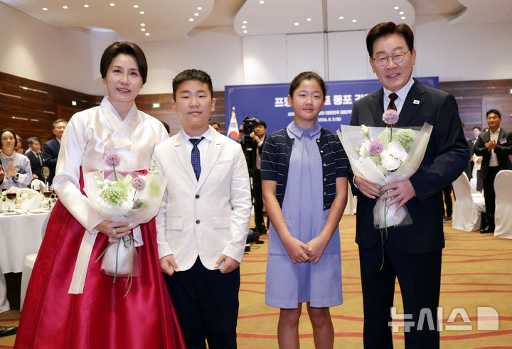 [프랑크푸르트=뉴시스] 김진아 기자 = 이재명 대통령과 김혜경 여사가 2일(현지 시간) 독일 프랑크푸르트의 한 호텔에서 열린 동포 오찬 간담회에서 화동과 기념촬영을 하고 있다. 2026.08.02. bluesoda@newsis.com