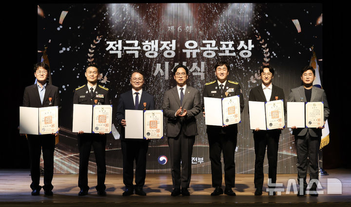 [서울=뉴시스] 김민재 행정안전부 차관이 3일 오후 정부세종청사 중앙동 대강당에서 열린 '제6회 적극행정 유공포상 시상식'에서 적극행정 우수성과자들에게 훈장을 전수한 뒤 수상자들과 기념촬영을 하고 있다. (사진=행정안전부 제공) 2026.8.3 photo@newsis.com