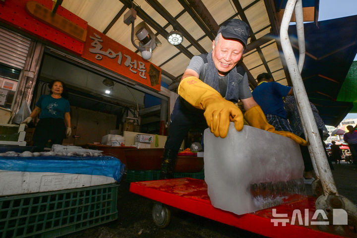 [전남광주=뉴시스] 이영주 기자 = 전남광주 동부권에 내려진 폭염중대경보가 광주동부 등으로 확대된 3일 오전 전남광주 광산구 송정5일장에서 한 상인이 얼음을 옮기고 있다. 2026.08.03. leeyj2578@newsis.com