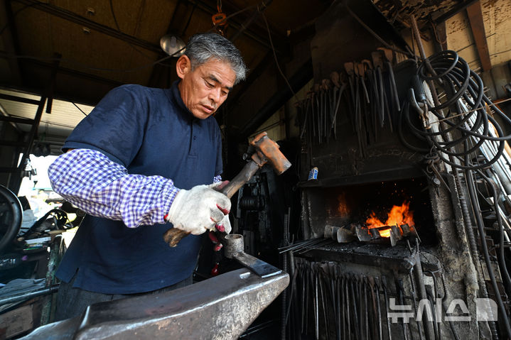 [전남광주=뉴시스] 이영주 기자 = 전남광주 동부권에 내려진 폭염중대경보가 광주동부 등으로 확대된 3일 오전 전남광주 광산구 송정5일장에서 대장간을 운영하는 최종호(62)씨가 곡괭이를 만들고 있다. 2026.08.03. leeyj2578@newsis.com