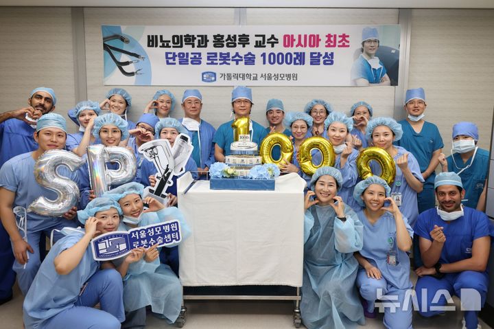 [서울=뉴시스] 홍성후 서울성모병원 비뇨의학과 교수가 3일 아시아·태평양 지역 최초로 단일공(SP) 비뇨기 로봇수술 개인 1000례를 달성하고 의료진과 기념사진을 촬영하고 있다. (사진= 서울성모병원 제공)