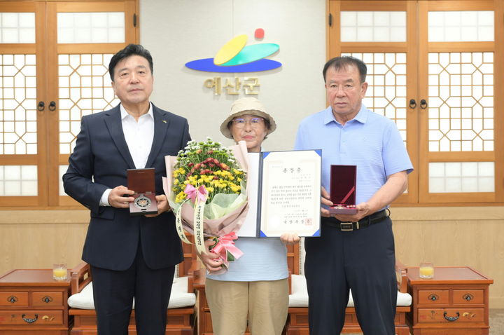 [예산=뉴시스] 충남 예산군청 상황실에서 지난 3일 6·25전쟁에 참전해 전사한 서울 서초구 출생 고 이학신 하사 유족인 이영실(가운데)씨에게 화랑무공훈장이 전수된 후 기념 사진 촬영이 이어지고 있다. (사진=예산군 제공) 2026.08.04. photo@neiwsis.com *재판매 및 DB 금지