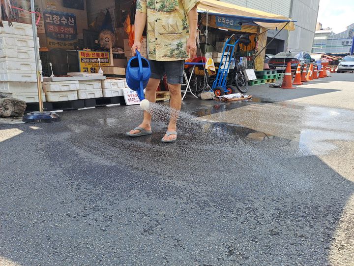 [서울=뉴시스] 권혜인 수습기자 = 지난 4일 서울 동대문구 청량리수산시장에서 상인이 바닥에 물을 뿌리는 모습.2026.08.05. khi@newsis.com *재판매 및 DB 금지