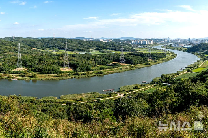 [전남광주=뉴시스] 정부와 한전은 현재 건설 중인 신장성변전소와 광주 군공항 이전 부지를 연결하는 신규 송전망을 지방도 49호선인 '빛가람장성로'와 황룡강변을 따라 설치하는 방안을 우선 검토하고 있다. 그림은 '황룡강변 송전선로 상상도' (이미지=생성형 AI 제작) *재판매 및 DB 금지