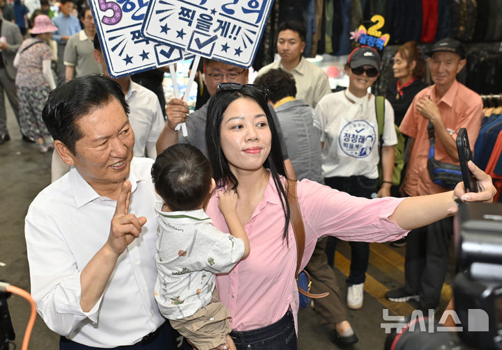 [전남광주=뉴시스] 박기웅 기자 = 정청래 더불어민주당 당대표 후보가 4일 전남광주 북구 말바우시장을 방문해 한 시민과 기념사진을 찍고 있다. 2026.08.04. pboxer@newsis.com