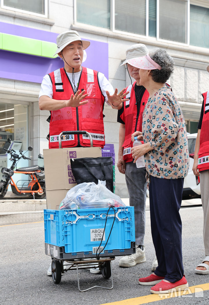 [서울=뉴시스] 김금보 기자 = 오세훈 서울시장이 4일 서울 용산구 효창동 일대 골목에서 폐지를 수집하는 어르신에게 폭염예방키트를 전달하고 대화를 하고 있다. 2026.08.04. kgb@newsis.com