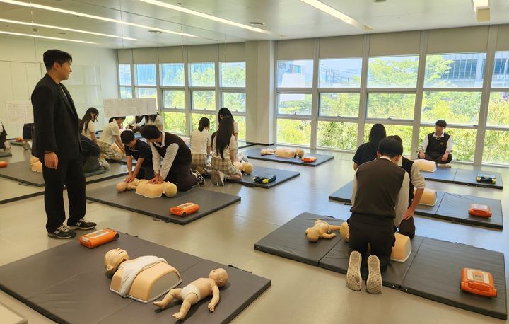 [부산=뉴시스] 에어부산 '드림스쿨'에 참여한 고등학생들이 AED 사용법을 배우며 기내 응급환자 발생시 대응요령을 익히고 있다. (사진=에어부산 제공) 2026.08.05. photo@newsis.com *재판매 및 DB 금지