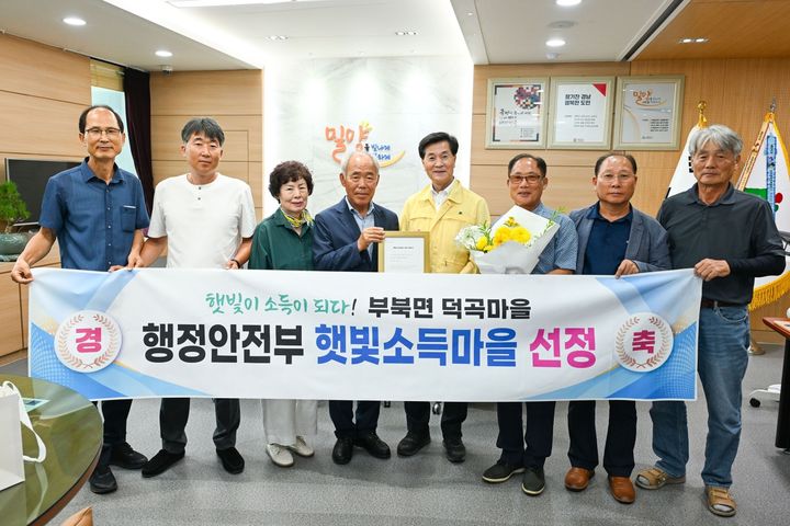 [밀양=뉴시스] 햇빛소득마을 선정확인서 전달식에서 덕곡마을 주민들이 기념촬영을 하고 있다. (사진=밀양시 제공) 2026.08.05. photo@newsis.com *재판매 및 DB 금지