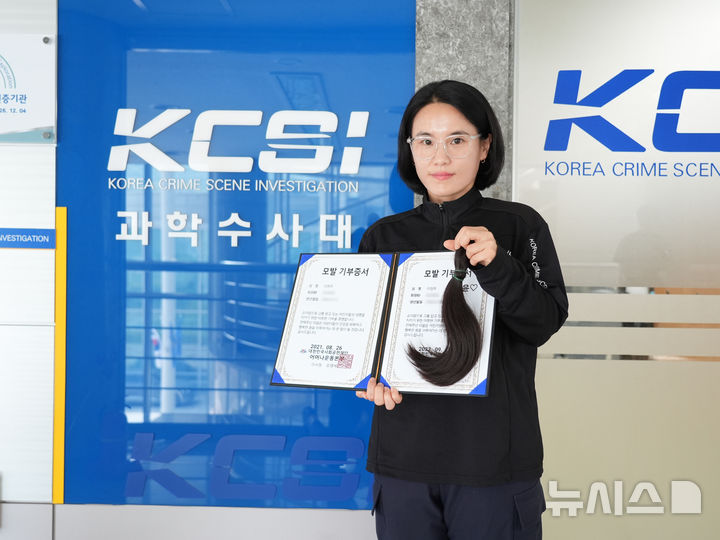 [청주=뉴시스] 이현주 충북경찰청 과학수사계 경사가 5일 충북청에서 자신이 기부한 머리카락과 인증서를 들고 기념촬영을 하고 있다. (사진=충북경찰청 제공) 2026.08.05. photo@newsis.com