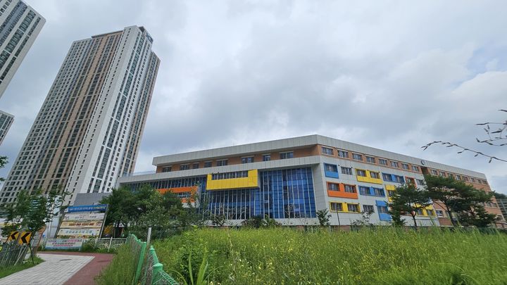 [안산=뉴시스] 문영호 기자 = 안산해솔초등학교 전경. 왼쪽으로 그랑시티자이 아파트가 보이고, 앞쪽에 자율·체육 공간 조성을 추진 중인 유휴부지가 보인다. 2026.08.05. sonanom@newsis.com *재판매 및 DB 금지