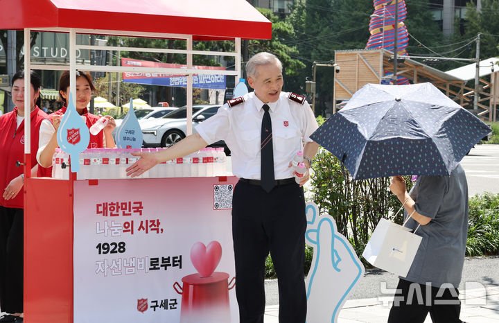 [서울=뉴시스] 김금보 기자 = 김병윤 구세군한국군국 사령관과 대원들이 5일 서울 종로구 세종대로 사거리에서 무더위 생수 나눔 캠페인을 하고 있다. 2026.08.05. kgb@newsis.com
