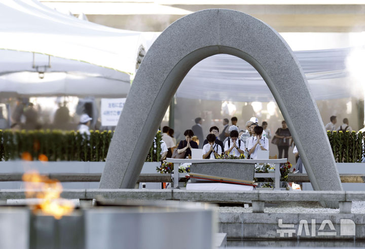 [히로시마=AP/뉴시스] 다카이치 사나에(高市早苗) 일본 총리는 6일 히로시마(広島)에서 열린 '원자폭탄 사몰자 위령식·평화기념식(이하 기념식)'에 참석해 비핵3원칙을 "견지하고 있다"고 밝혔다. 사진은 6일 일본 히로시마에 위치한 히로시마 평화기념공원 원자폭탄 희생자 추모비 앞에서 방문객들이 추모하는 모습. 2026.08.06.