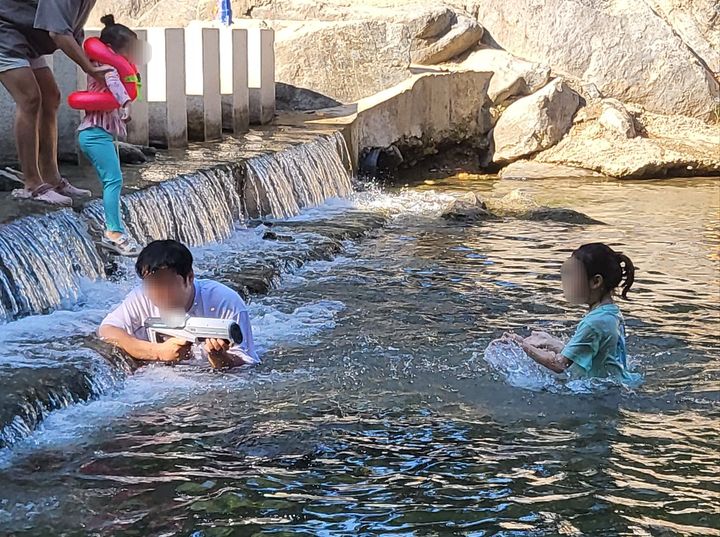 [광주=뉴시스] 최유리 인턴기자=광자원 계곡에서 물총놀이를 하는 박성민 씨와 박시아 양. *재판매 및 DB 금지