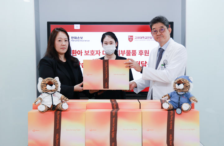 [서울=뉴시스] 지난 5일 소아암 환아 보호자(가운데)가 웰니스 키트를 전달받고 있다. (왼쪽부터) 배주영 한화손보 브랜드마케팅팀 상무, 소아암 환아 보호자, 한승범 고려대안암병원장. (사진=한화손보 제공) 2026.08.06. photo@newsis.com *재판매 및 DB 금지