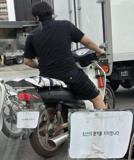 [서울=뉴시스]헬멧을 쓰지 않은 한 오토바이 운전자가 '당신의 용기를 지지합니다'라는 문구가 적힌 흰색 종이로 뒷번호판을 가린 채 도로를 주행하고 있다. 사진 보배드림 게시글 사진 캡처 *재판매 및 DB 금지