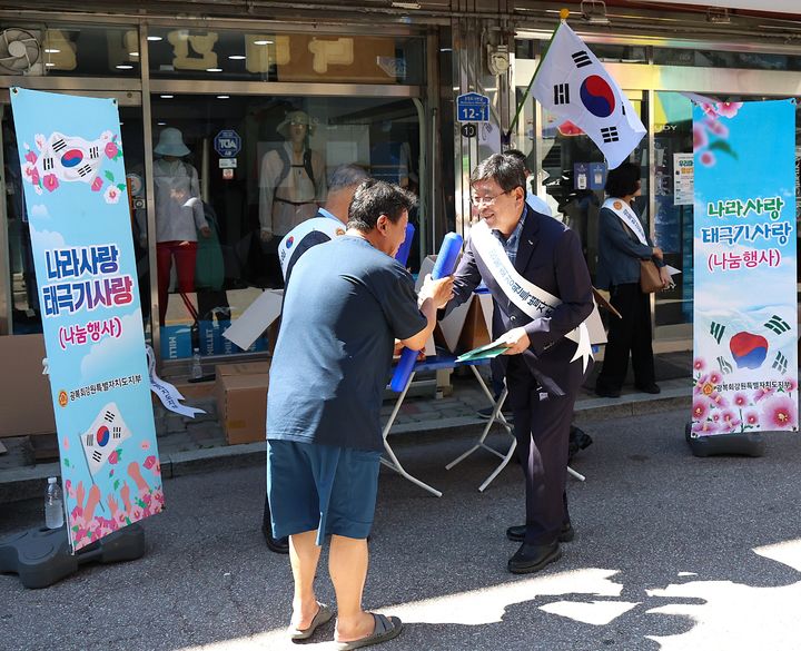 [횡성=뉴시스] 광복 81주년을 앞두고 장신상 횡성군수가 횡성전통시장에서 열린 태극기 나눔 행사에 참여해 군민들에게 태극기를 전달하고 있다. (사진=횡성군 제공) 2026.08.06. photo@newsis.com *재판매 및 DB 금지