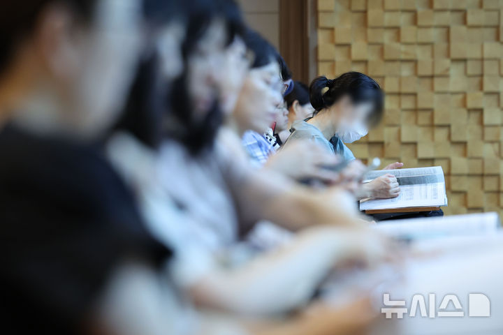 [서울=뉴시스] 권창회 기자 = 6일 서울 용산구 용산꿈나무종합타운에서 열린 2027학년도 수시모집 지원전략 특강에서 학부모들이 수시전략 책을 보고 있다. 2026.08.06. kch0523@newsis.com