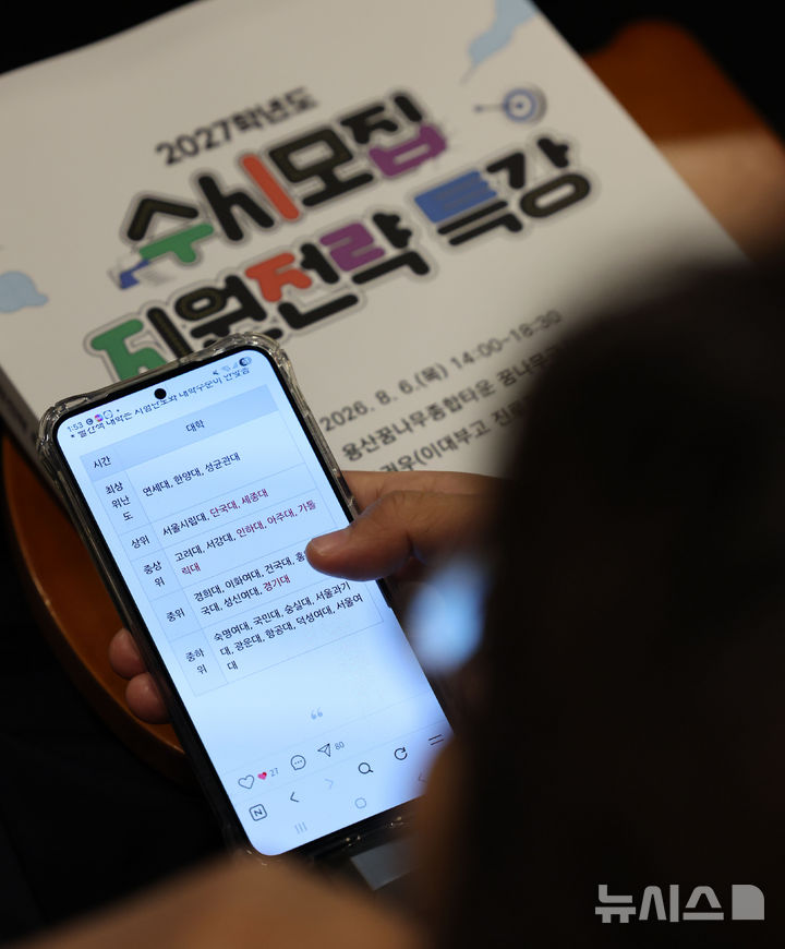 [서울=뉴시스] 권창회 기자 = 6일 서울 용산구 용산꿈나무종합타운에서 열린 2027학년도 수시모집 지원전략 특강에서 학부모들이 수시전략 책을 보고 있다. 2026.08.06. kch0523@newsis.com