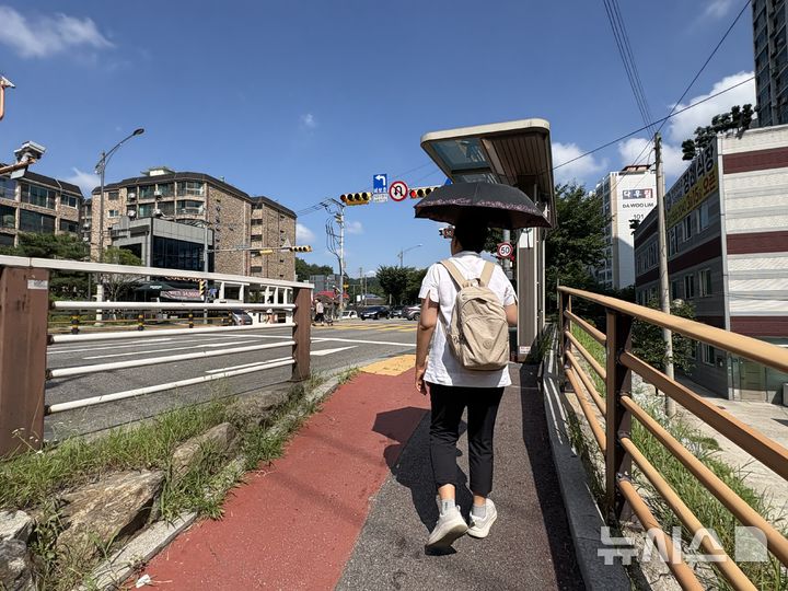 [구리=뉴시스] 신유림 기자=낮 최고기온이 39도까지 치솟았던 지난 5일 오전 경기 구리시 인창동 일대에서 생활지원사 유모씨가 양산을 쓰고 담당 어르신의 집으로 향하고 있다. 2026.08.07. spicy@newsis.com