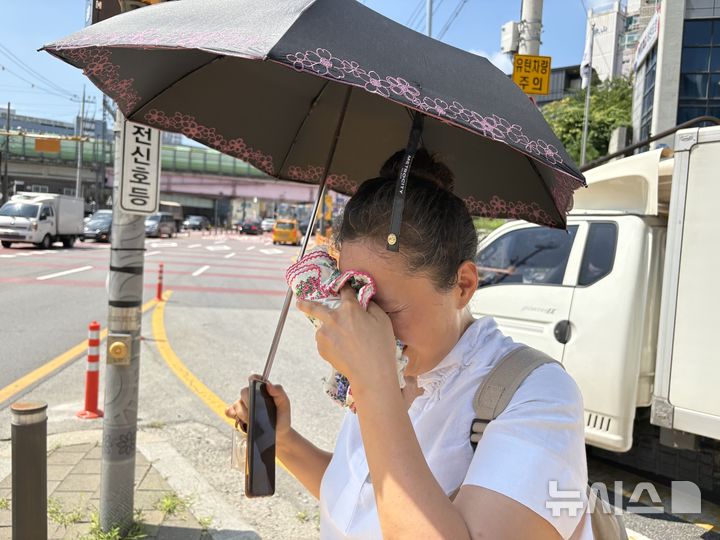 [구리=뉴시스] 신유림 기자=낮 최고기온이 39도까지 치솟았던 지난 5일 오전 경기 구리시 인창동 일대에서 생활지원사 유모씨가 꽃무늬 손수건으로 감싼 얼음물로 땀을 식히고 있다. 2026.08.07. spicy@newsis.com