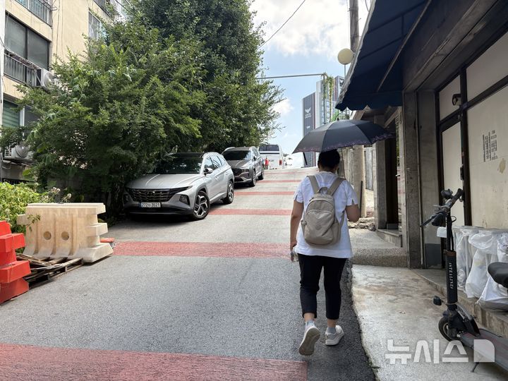 [구리=뉴시스] 신유림 기자=낮 최고기온이 39도까지 치솟았던 지난 5일 오전 경기 구리시 인창동 일대에서 생활지원사 유모씨가 양산을 쓴 채 언덕길을 올라 담당 어르신의 집으로 향하고 있다. 2026.08.07. spicy@newsis.com