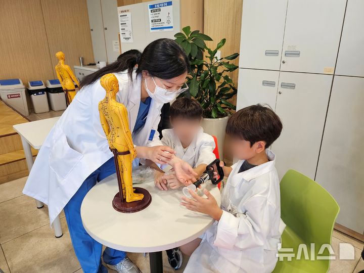 [서울=뉴시스] 진로직업체험 프로그램에 참여한 학생들이 병원 내부 시설을 둘러보고 있다. (사진= 인천자생한방병원 제공)