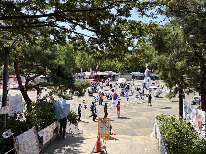 [서울=뉴시스] 김서하 인턴기자 = 연일 폭염이 계속되는 가운데 투표용지 부족 사태에 항의하는 개표소 봉쇄 시위가 64일째 이어지고 있는 7일 오전 서울 송파구 올림픽공원 핸드볼경기장 앞에서 참가자들이 태극기와 성조기를 흔들고 있다. 2026.08.07. photo@newsis.com *재판매 및 DB 금지